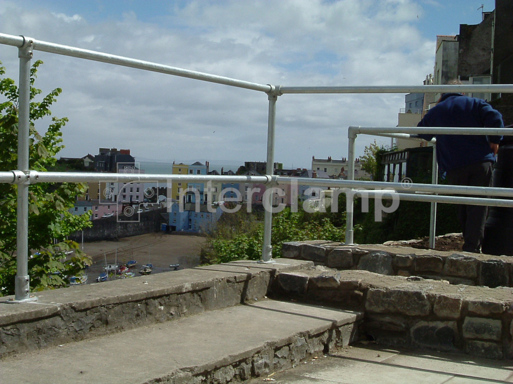 Interclamp tube clamp handrail installed along a viewing area at a seaside town, offering secure support for pedestrians against the scenic coastal view.